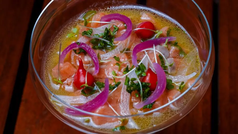 Filets de poisson nappés d'une marinade aux herbes et huile, dans un plat en verre